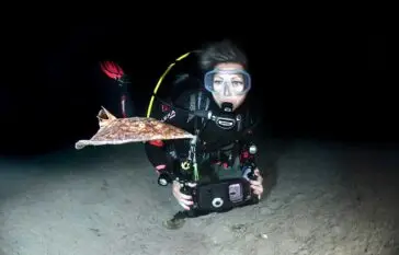 Atlantic Scuba Adventures Night Diver taking footage of fish underwater