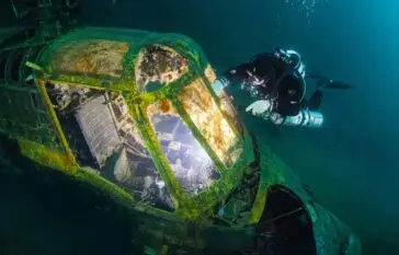 Scuba Diver underwater exploring a helicopter wreck