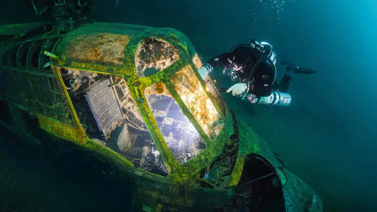 Scuba Diver underwater exploring a helicopter wreck