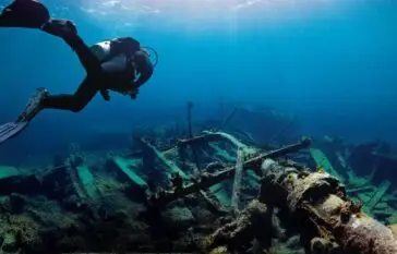 Scuba Diver underwater exploring a shipwreck