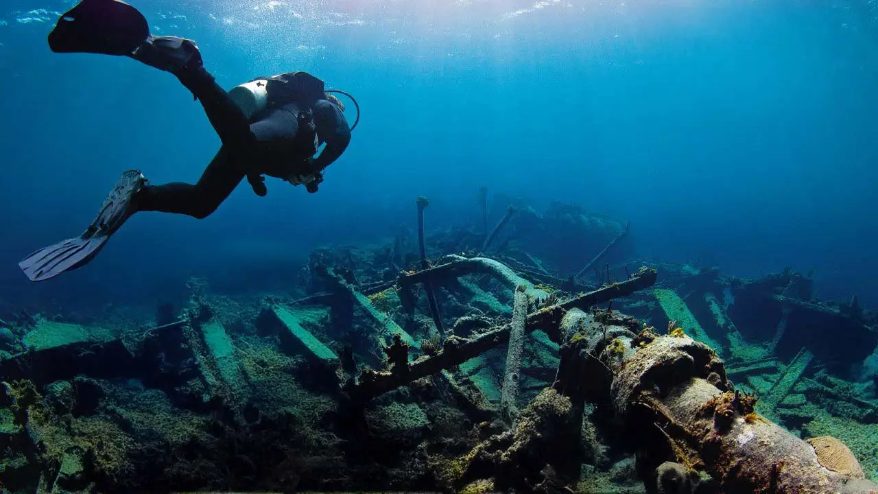 Scuba Diver underwater exploring a shipwreck