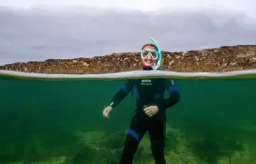 View of above and below water and Snorkeling Woman with head above water