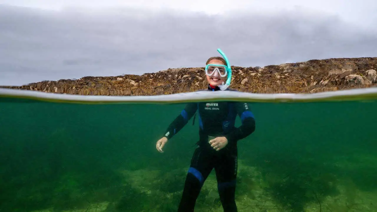View of above and below water and Snorkeling Woman with head above water